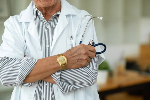一名职业中年男医生身穿医疗服 双臂交叉举着听诊器的剪影 — 图库照片