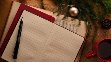 Boş defterini aç. İçinde kalem, kahve fincanı ve Noel ağacı olsun. Noel konsepti. en üstteki görünüm