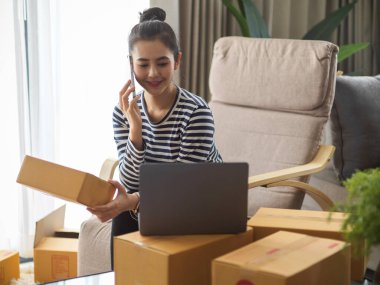 Çekici bir kadın e-ticaret şirketi sahibi, dizüstü bilgisayardaki hesabını kontrol etmek için telefonla sipariş almış..