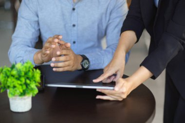 Ofiste dijital tablet bilgisayarda birlikte çalışan iki iş adamının kesilmiş görüntüsü. Takım, meslektaşlar.