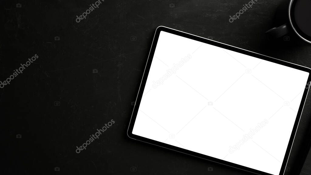 Digital tablet computer in white screen mockup and copy space on black background. top view