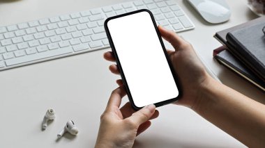 Ofisteki masanın üstünde akıllı telefon kullanarak yakın plan eller. Cep telefonu boş ekran modeli. aygıt teknolojisi kavramı.