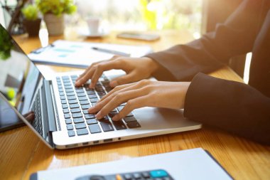 Masasındaki dijital dizüstü bilgisayarda çalışan kadın ya da iş kadınının görüntüsü. İnternet 'te arama, klavyede yazma, iş ortaklarına e-posta.