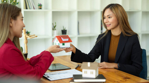 Азиатская женщина-агент по недвижимости встречается со своим клиентом для заключения договора аренды в офисе.