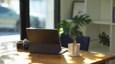 Dijital dokunmatik tablet bilgisayar ve kamera çalışma alanındaki bir masanın üzerinde. Serbest fotoğrafçı ekipmanı konsepti.