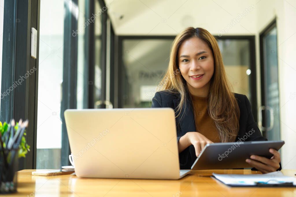 Female business employee working at her desk, sits in front of her laptop computer.