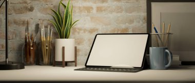 Modern çalışma alanı dijital tablet ya da dokunmatik tablet, boya aletleri, kırtasiye malzemeleri, tuğla duvarın üzerindeki masanın üzerindeki dekorlar. 3d görüntüleme, 3d illüstrasyon