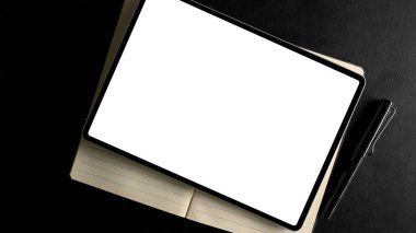 Modern karanlık çalışma masasında dijital tablet boş ekran modeli. Üst görünüm, düz uzanma