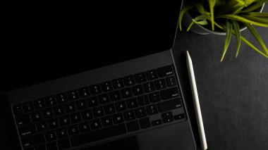 Klavyeli ve koyu renk kalemli modern tablet bilgisayar. Siyah arka plan. en üstteki görünüm