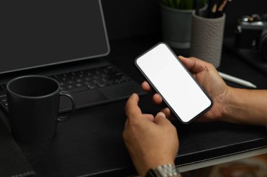 Akıllı telefon ya da cep telefonunu masanın üstünde tutan bir adam. Grafik panelinizi göstermek için boş telefon ekranı.