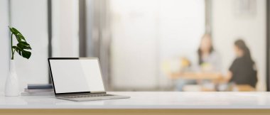 Laptop beyaz ekran modeli ve bulanık ofis arkaplanı üzerinde modern beyaz masa üzerinde bir kopya alanı. 3d görüntüleme, 3d illüstrasyon