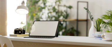 Arka planda bulanık en az oda üzerindeki beyaz masa üzerinde dijital tablet modeliyle ev konseptinde asgari çalışma alanı. Beyaz iç mekan ve yeşillik bitkileri odası. 3d görüntüleme, illüstrasyon