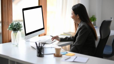 Başarılı bir iş kadını, kadın finans analistleri ya da bankacı ofis masasındaki bilgisayarında çalışıyor. Bilgisayar boş ekran modellemesi.