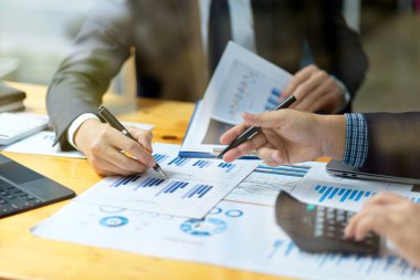 Bir mali yönetim heyetinin kırpılmış görüntüsü toplantıda mali strateji planlarını tartışıyor ve analiz ediyor.
