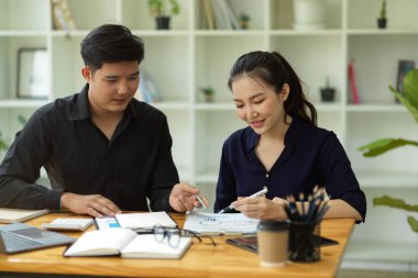 Modern ofis işyerinde birlikte çalışan iki genç finans öğrencisi. Takım çalışması. İş adamı ve iş kadını.