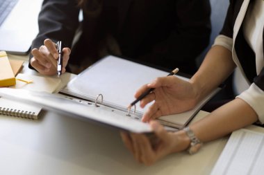 Profesyonel bir yöneticinin toplantıda rapor belgelerini incelerken çekilmiş görüntüsü..