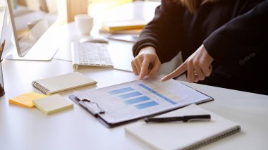 Businesspeople pointing on a report paperwork to explains their financial report. cropped shot