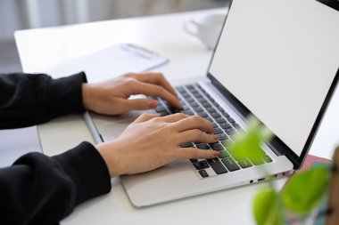 A female college student or businesswoman typing on laptop keyboard. A female using laptop computer. A girl working on her portable notebook computer. cropped