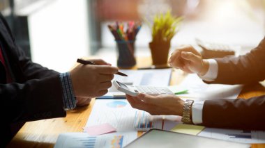 Cropped shot of executive manager managing team and project budget report with his colleagues in the office.