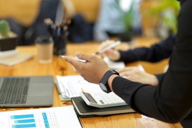 Focusing businessman's hand image. Businessman working with her coworker at the office desk.