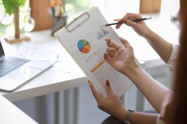 Cropped and close-up image of a Business team analysing a financial report, checking the profit summary report in the office.
