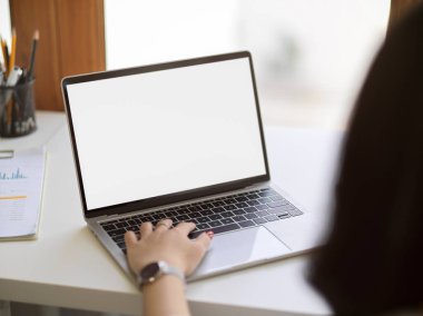 Close-up, Business woman using portable laptop computer at her desk. Laptop blank screen mockup