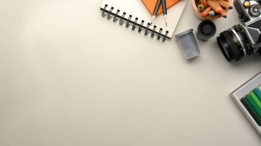 Photographer or designer workspace with stationery, camera and copy space on white background. top view