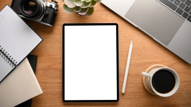 Digital tablet touchpad computer white screen mockup for display your graphic on modern wooden worktable. top view