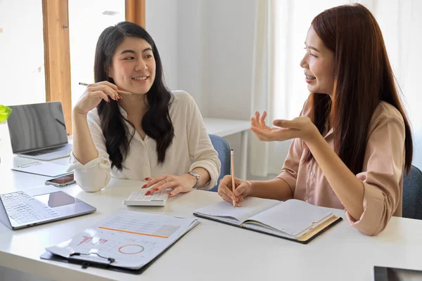 Happy and cheerful business colleagues working and brainstorming a business campaign together in the office