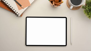 Minimal workspace with wireless tablet computer blank screen mockup and stationery on white table background. top view