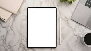 Digital tablet computer white screen mockup on marble worktable background. top view