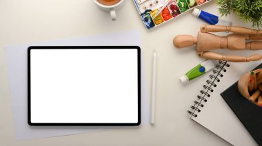 Artist workspace. Digital tablet touchpad white screen mockup and painting tools on white table.