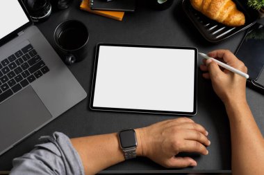 Professional businessman using digital tablet computer at his modern office desk. Tablet touchpad blank screen mockup. top view
