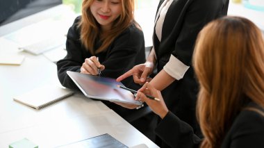 Businesswomen in the media planner team are discussing and brainstorming about their new product launching date plan in the office.