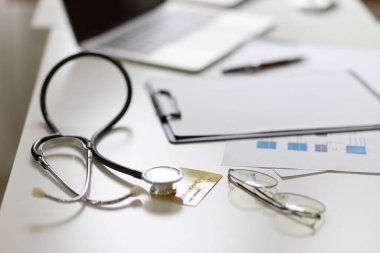 Doktor ya da doktor masası konsepti. Stetoskop, tıbbi dosya, gözlük ve dizüstü bilgisayar. yakın plan