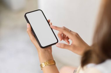 Akıllı telefon kullanan, kendine güvenen ve zarif bir kadının görüntüsü çevrimiçi alışveriş uygulamalarında zaman harcıyor. telefon boş ekran.
