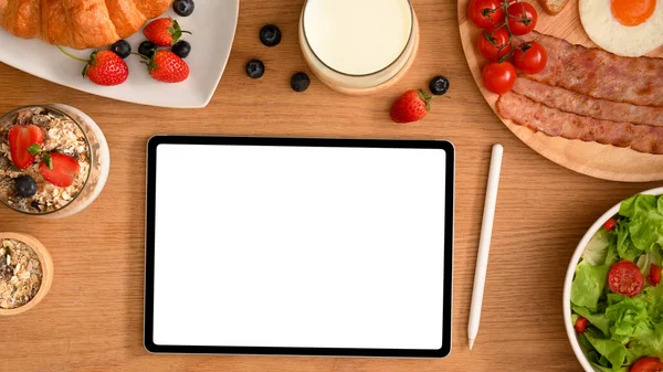 デジタルタブレットのブランクスクリーンモックアップ 朝食セット おいしいペストリーを備えたワークスペース トップ表示 レシピやメニューのテンプレート — ストック写真