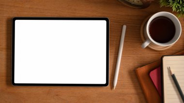 Basit ahşap işlemeli beyaz ekran tablet bilgisayar, stil kalem, kahve fincanı ve kırtasiye malzemesi..