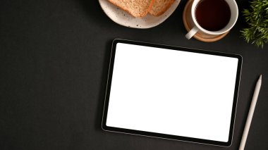 Modern siyah çalışma alanında grafik pankartınızı göstermek için tablet dokunmatik bilgisayar beyaz ekranı.