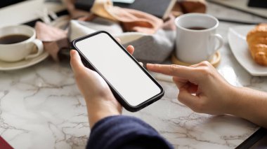 Sabahları akıllı telefonundan e-postalarını kontrol eden bir kadının yakın plan görüntüsü. telefon boş ekran