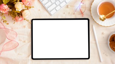 Dijital tablet dokunmatik ekranında kopya alanı olan kadınsı çalışma alanı. Güzel dekorlu kadınlar bürosu masası. en üstteki görünüm