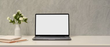 Laptop boş ekran maketi, aksesuarlar ve çatı katı duvarı üzerine kopyalama alanı olan basit bir çalışma alanı.