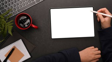 Modern karanlık çalışma alanı üzerinde dijital tablet bilgisayarda bir kadının kullanım, çalışma, çizim ve çizim.