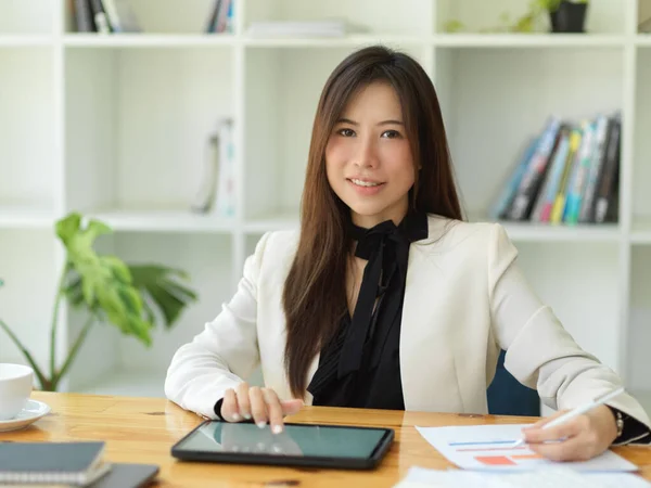 快乐的女商人坐在办公室里 在她的办公桌前使用数字便携式平板触摸板电脑 — 图库照片