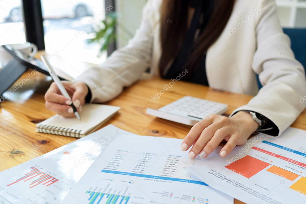 Business people or female worker doing her financial assignment in the office. financial report on the table.