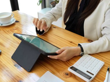 Kapanışta, bir kadın muhasebeci bir tablet üzerinde çevrimiçi mali rapor hazırlıyor. Bir iş kadını mali istatistikleri analiz etmek için tablet dokunmatik tablet kullanır.