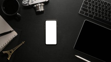 Modern siyah çalışma istasyonu üst görünümü, düz uzanan akıllı telefon boş ekran modeli ve siyah arkaplan dekorları.