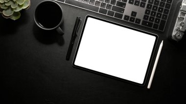 Elektronik cihazları olan modern karanlık ofis masası, klavye, stilus kalem ve tablet beyaz ekran modeli. en üstteki görünüm