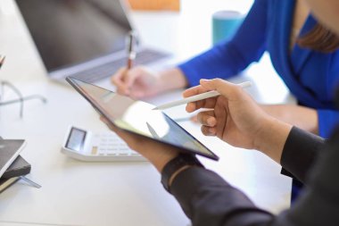 İş toplantısında taşınabilir tablet dokunmatik ped kullanan bir iş adamının yakın plan görüntüsü.