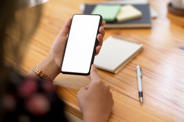 Ahşap ofis masasının üzerinde elinde beyaz ekran akıllı telefonun bir kopyası. yakın plan resim